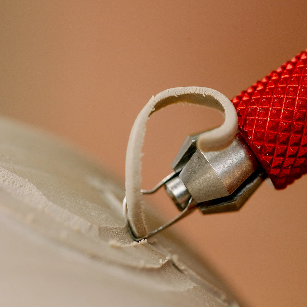 Close view of the BuschKraft Dragonfly medium P-shape blade lifting a ribbon of clay