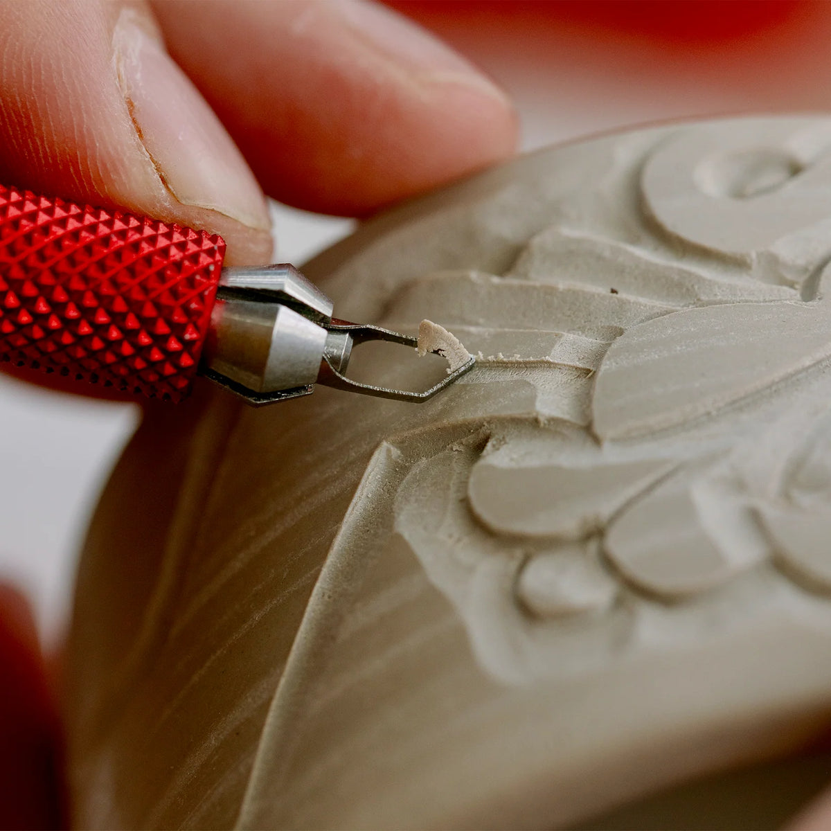 Relief carving into a clay bowl with the BuschKraft Dragonfly medium chisel blade