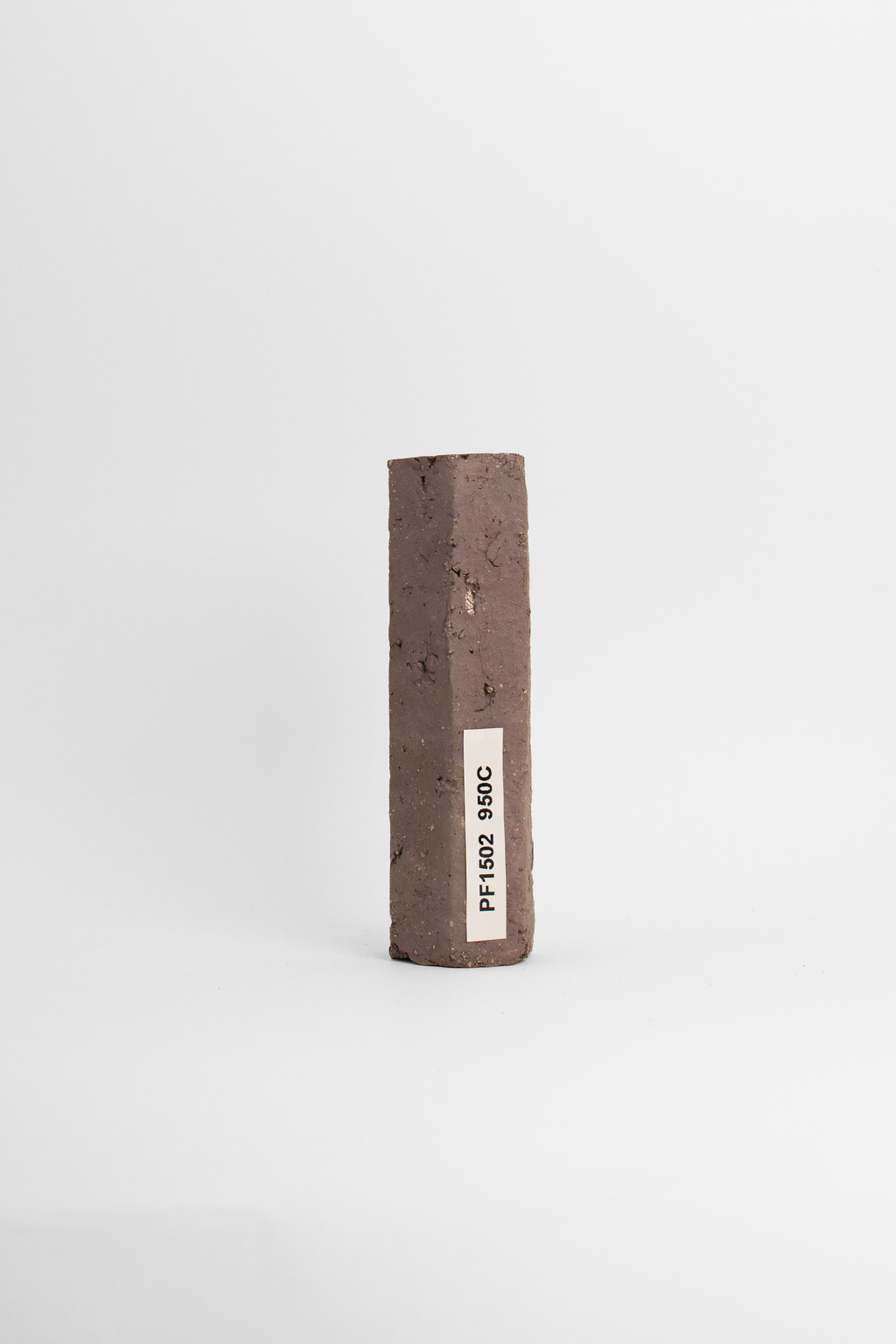 PF660 test tile fired to 950C, a dusty plum-brown with coarse grog showing