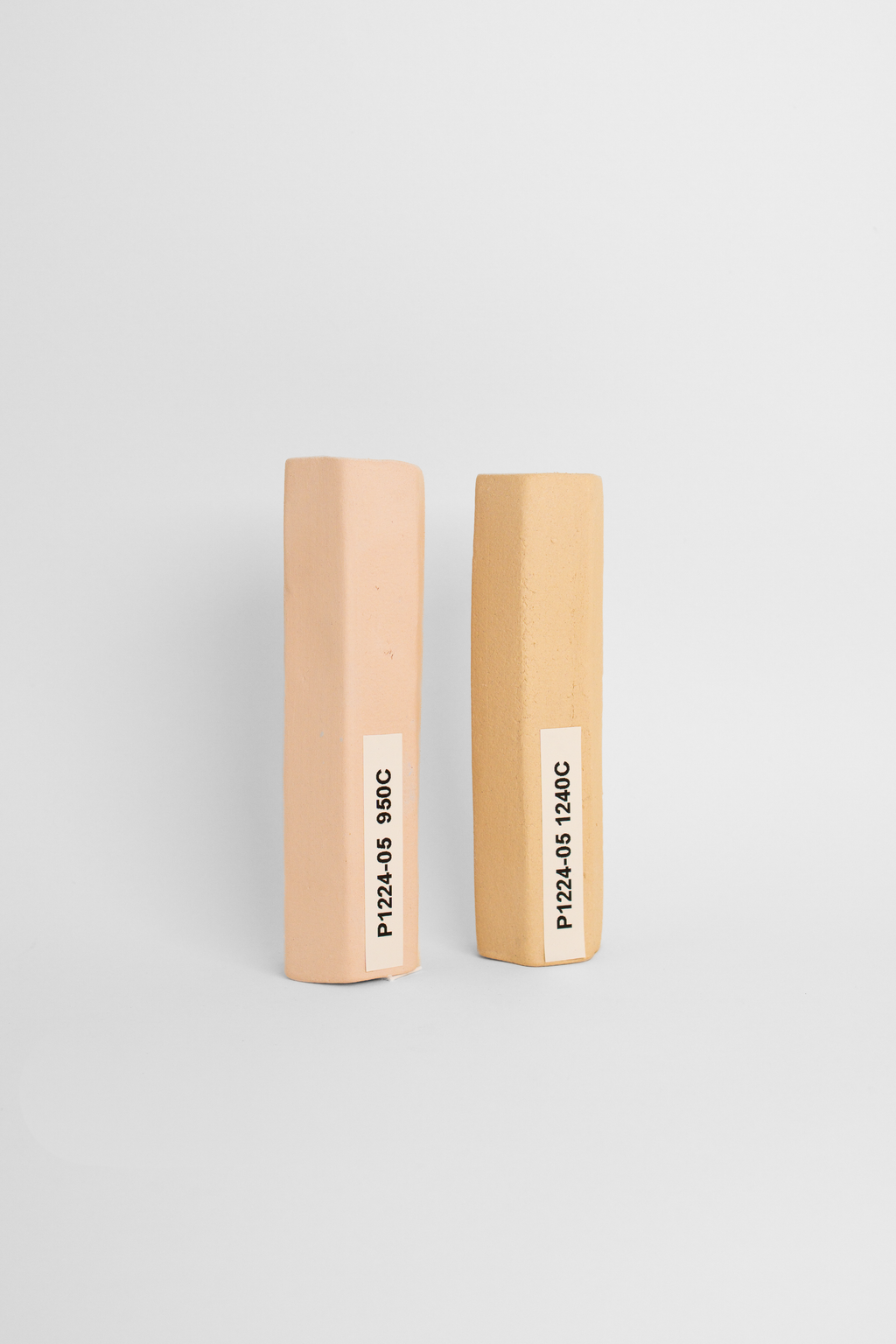 ES200 paper clay test tiles side by side, pink-buff at 950C and warmer tan at 1240C
