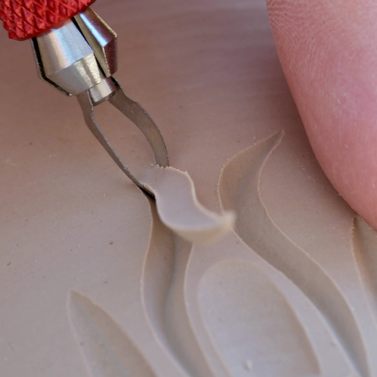 A BuschKraft Dragonfly Arc blade pulling a deep groove through clay