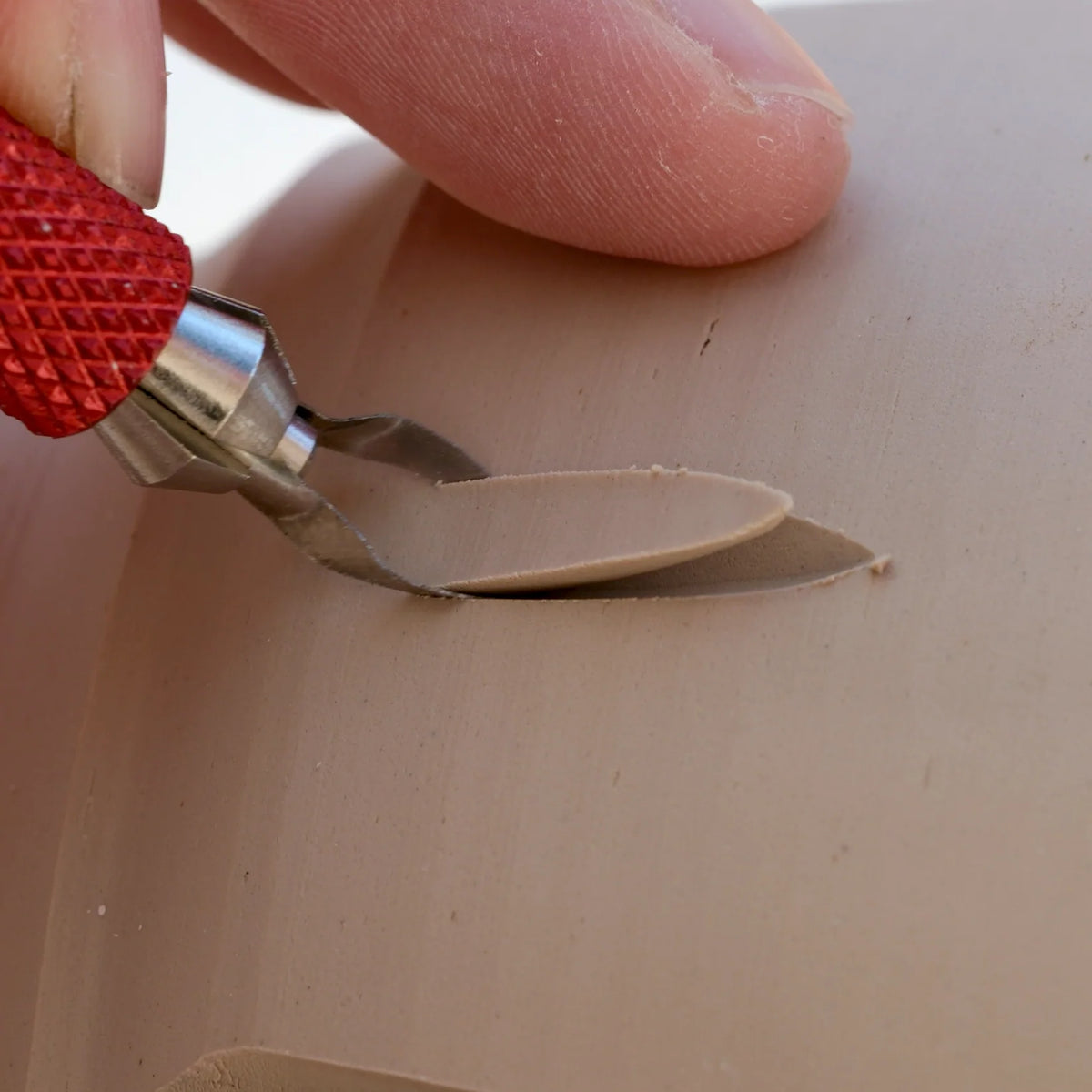 A BuschKraft Dragonfly Arc blade cutting a leaf shape into a pot