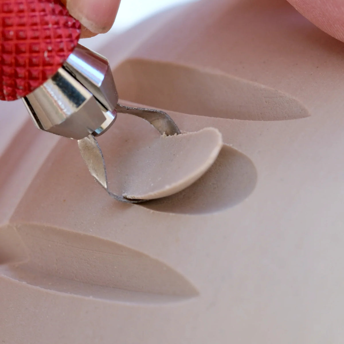 A BuschKraft Dragonfly Arc blade carving a deep curved channel into a bowl