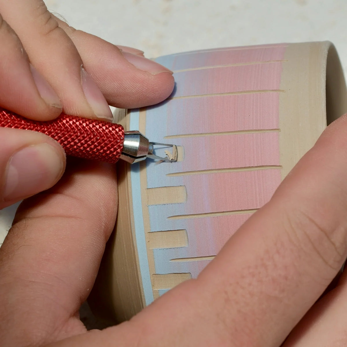 Cutting a band of rectangular windows through pink and blue slip with a BuschKraft Dragonfly square blade