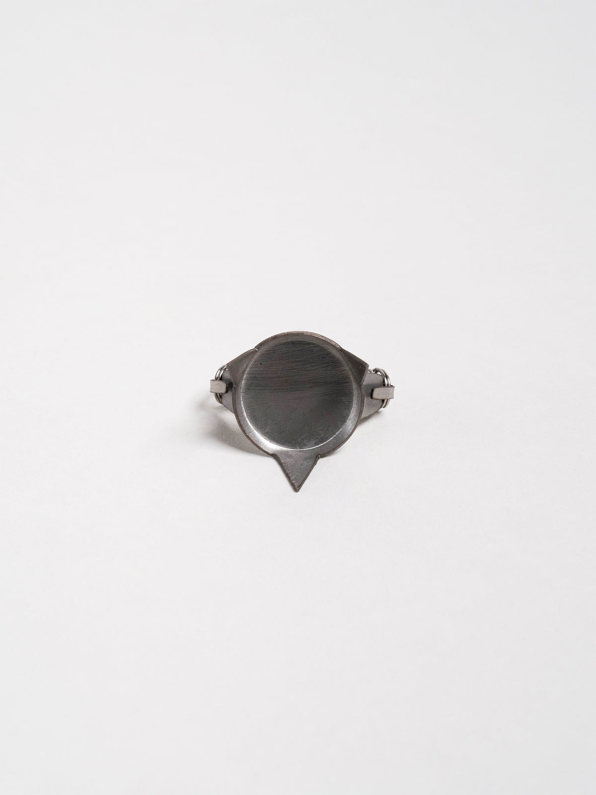 Hand displaying a pair of compact metal tools used to suspend lightweight ceramic pieces for glaze dipping.