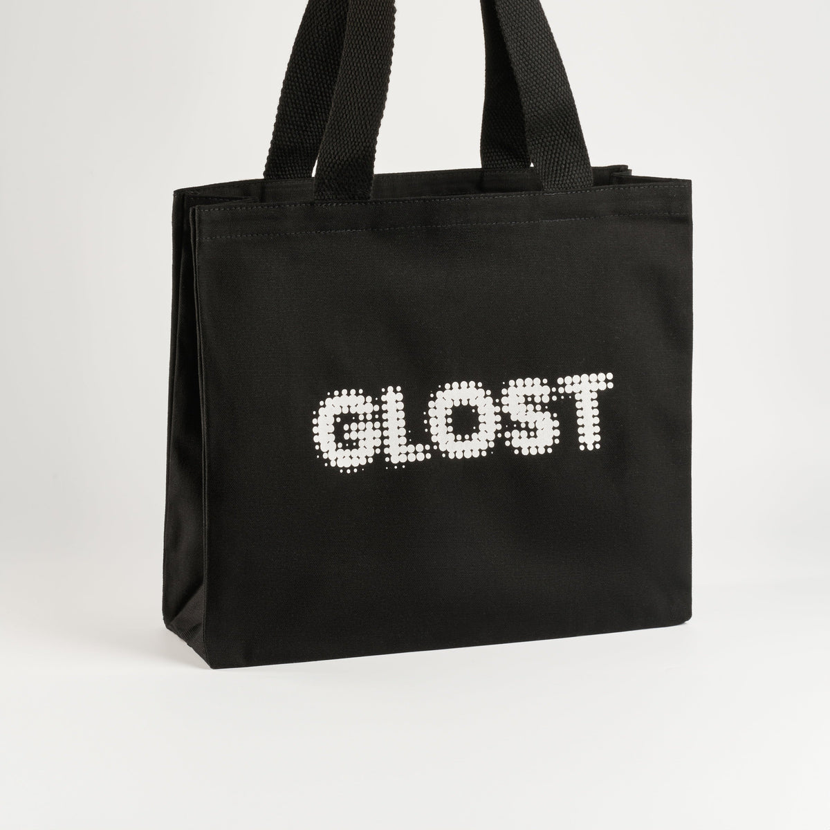 GLOST Tote Bag is crafted in the UK from high-quality cotton. This sturdy bag is designed to withstand the demands of the pottery studio, making it ideal for carrying glazes, tools, and other essentials. Featuring the bold GLOST logo, it combines durability with style, offering a practical solution for ceramic artists on the go.