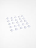 A neat grid of small white ceramic kiln stilts arranged on a flat white surface, each shaped like a low cone.