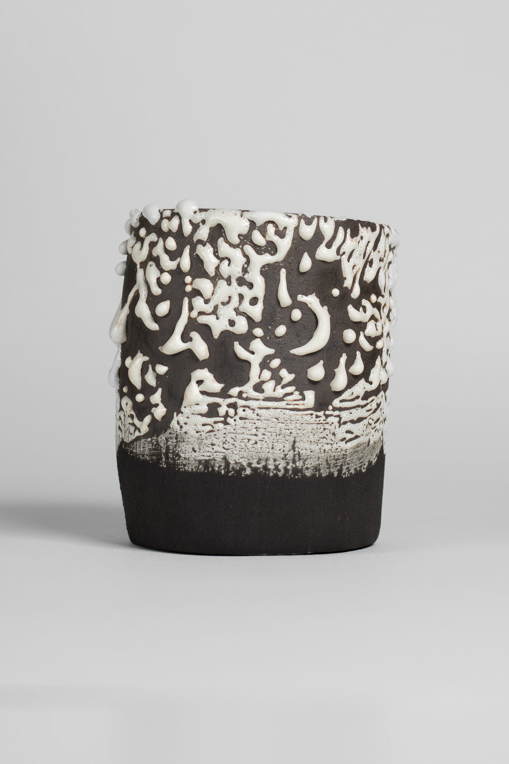Crawl Textured White glaze on a black clay cylinder, white glaze pulled into islands