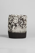Crawl Textured White glaze on a black clay cylinder, white glaze pulled into islands