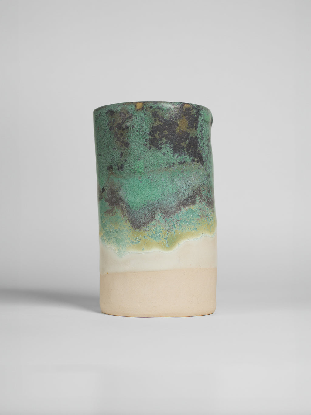 Malachite Green on a thrown cylinder, mottled green breaking to dark brown over a cream band and raw clay foot