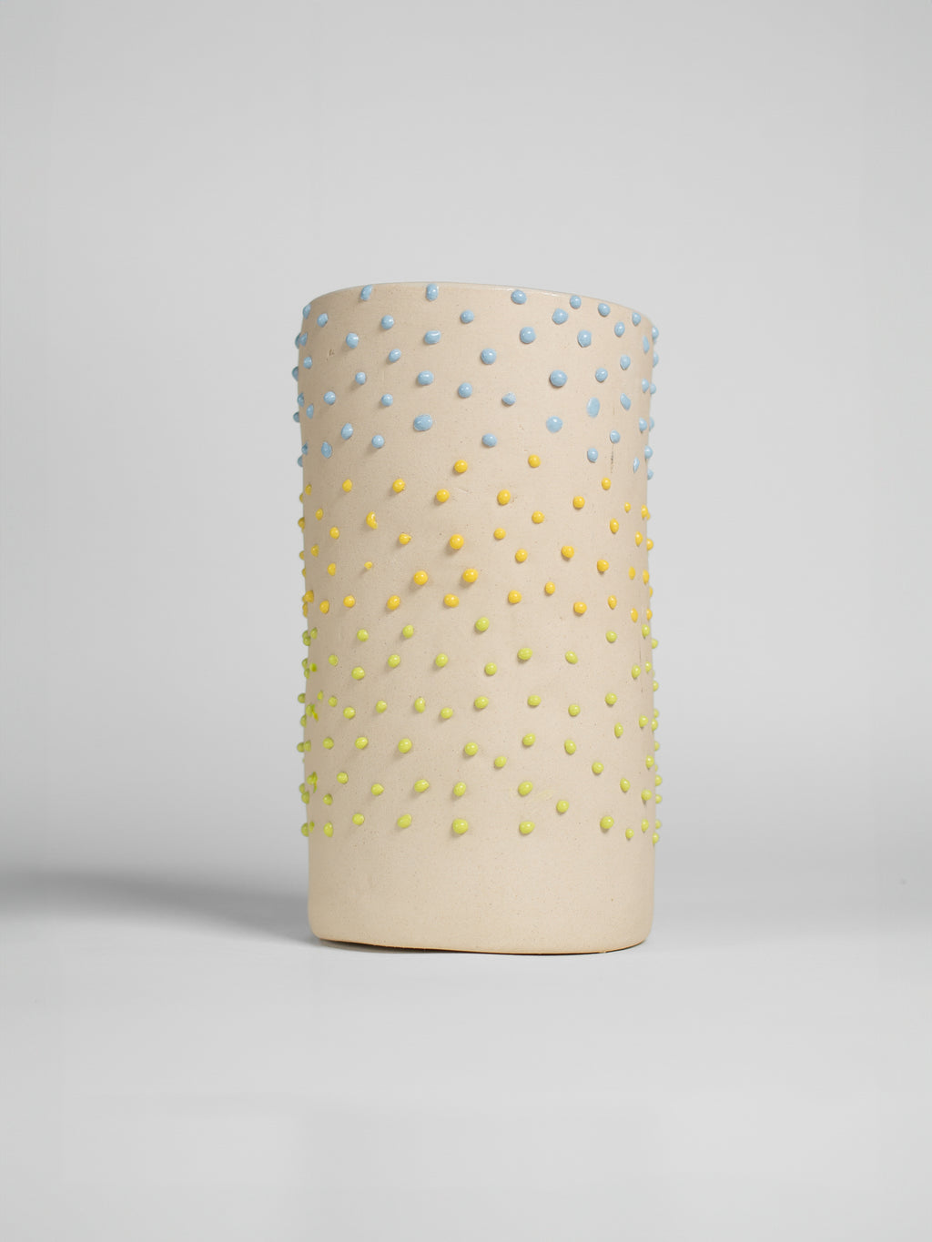 Green Liquid Gloop glaze on a test cylinder, green droplets over a cream ground