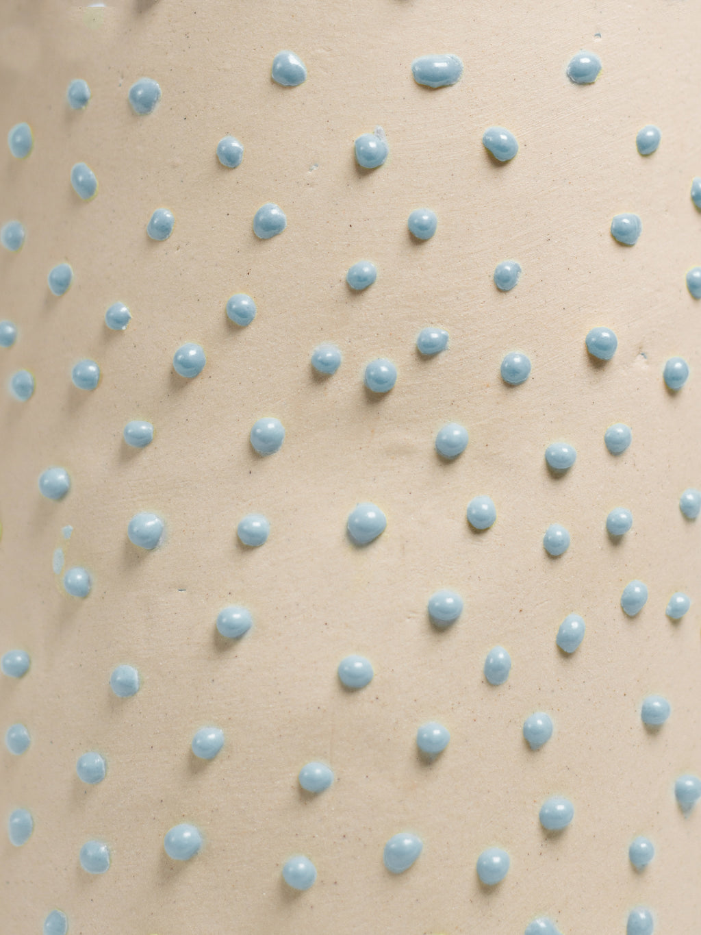 Close up of Light Blue Liquid Gloop, blue droplets across a cream surface