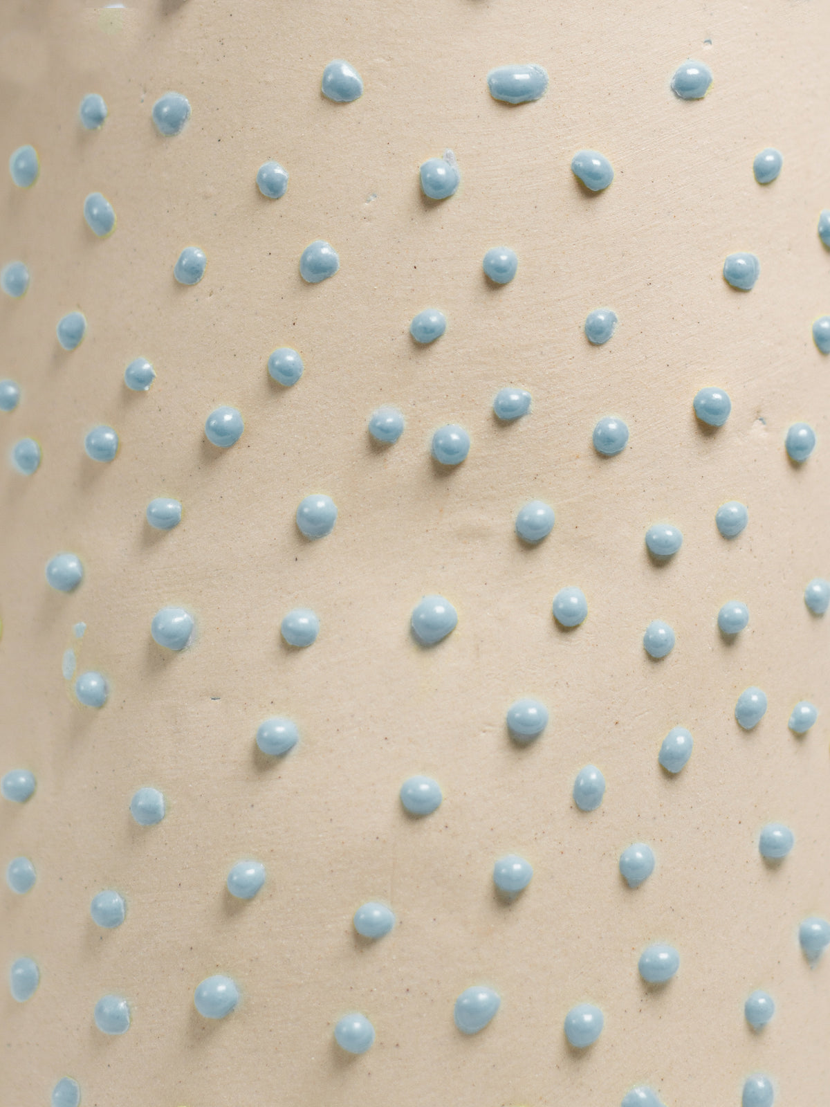 Close up of Light Blue Liquid Gloop, blue droplets across a cream surface