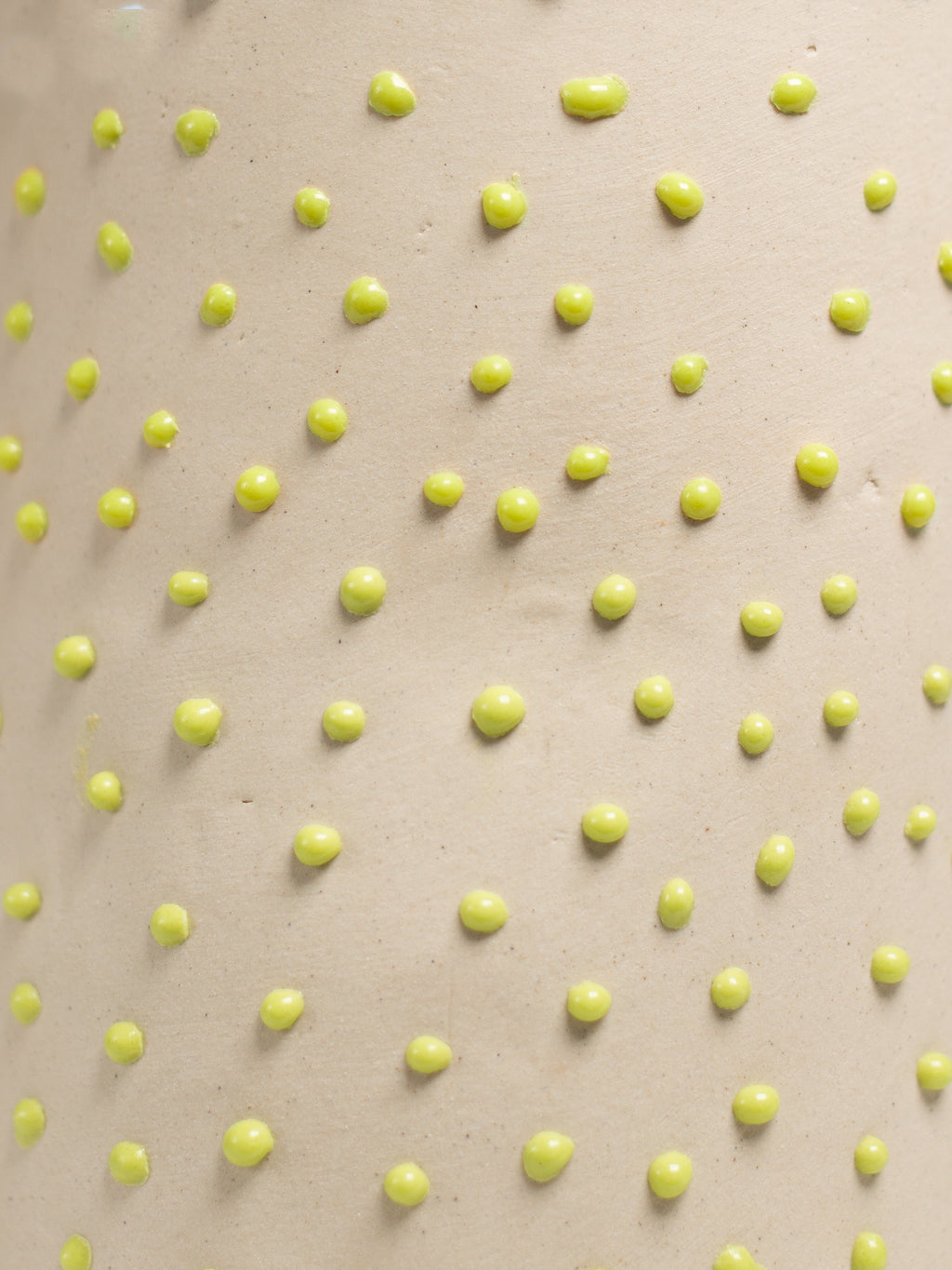 Close up of Green Liquid Gloop, raised green droplets across a cream surface
