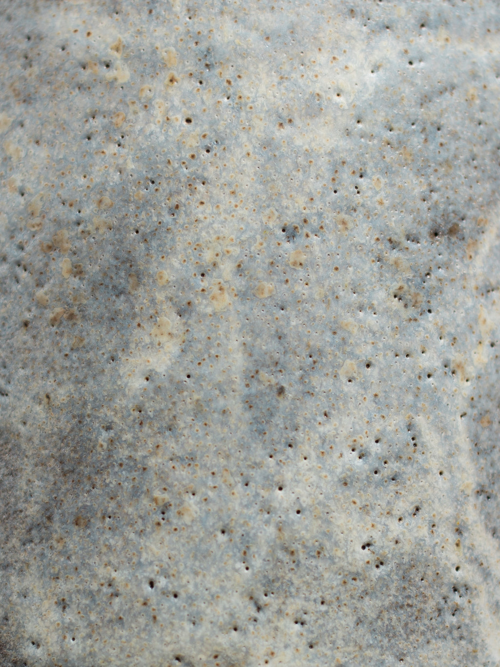 Close view of the Milky Matt White surface, dense cream and grey speckle with fine pinholing