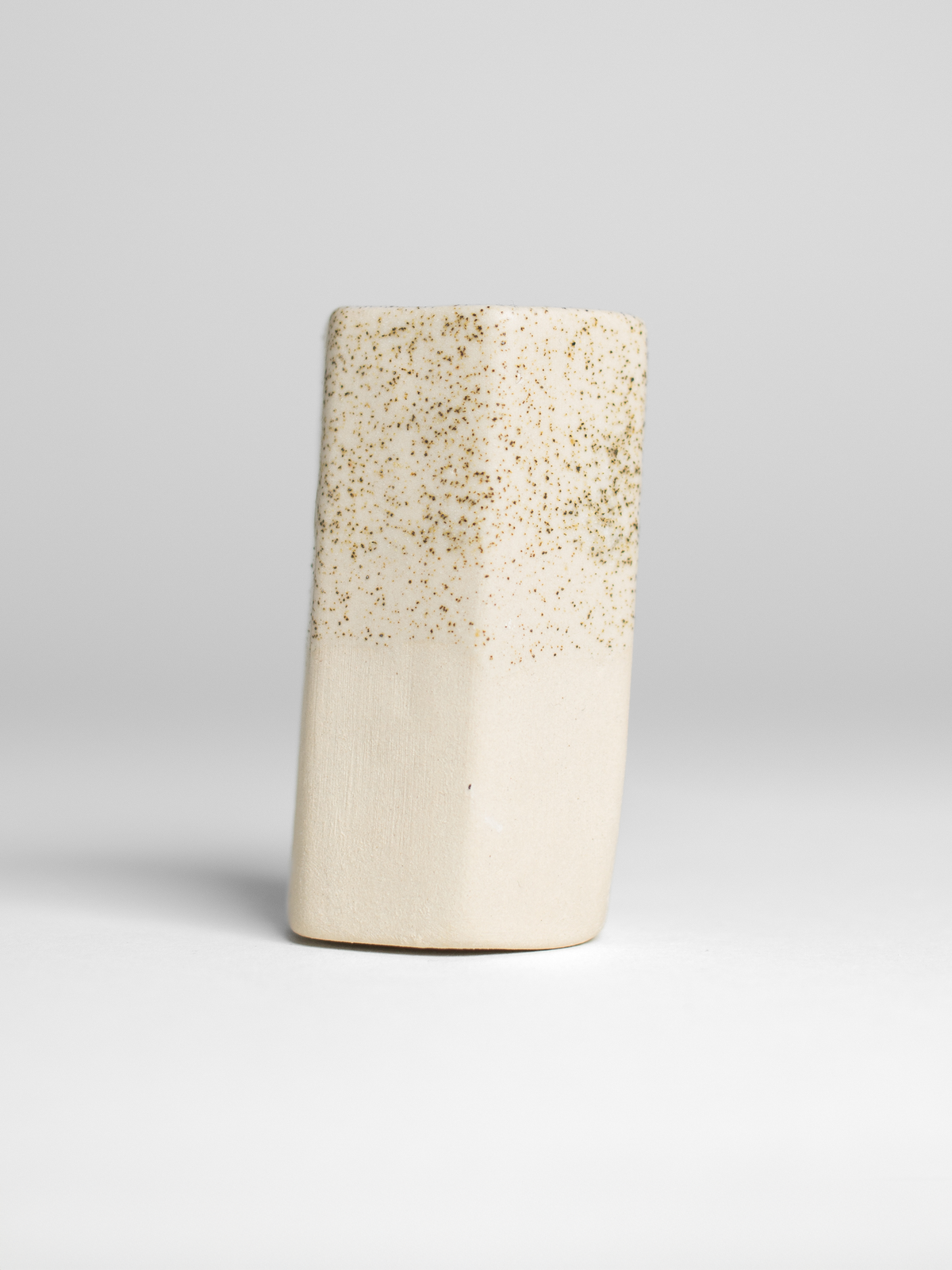 Speckle Matt glaze on a fired test cylinder, pale oatmeal with dark speckles