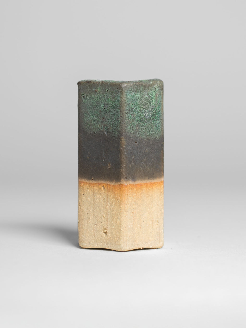 Malachite Green test tile, thin green at the top fading to a dark olive band over pale clay