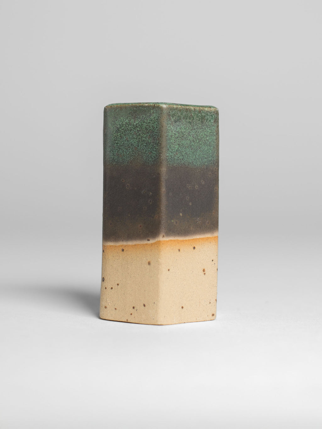 Malachite Green test tile on speckled clay, green over a broad dark brown band