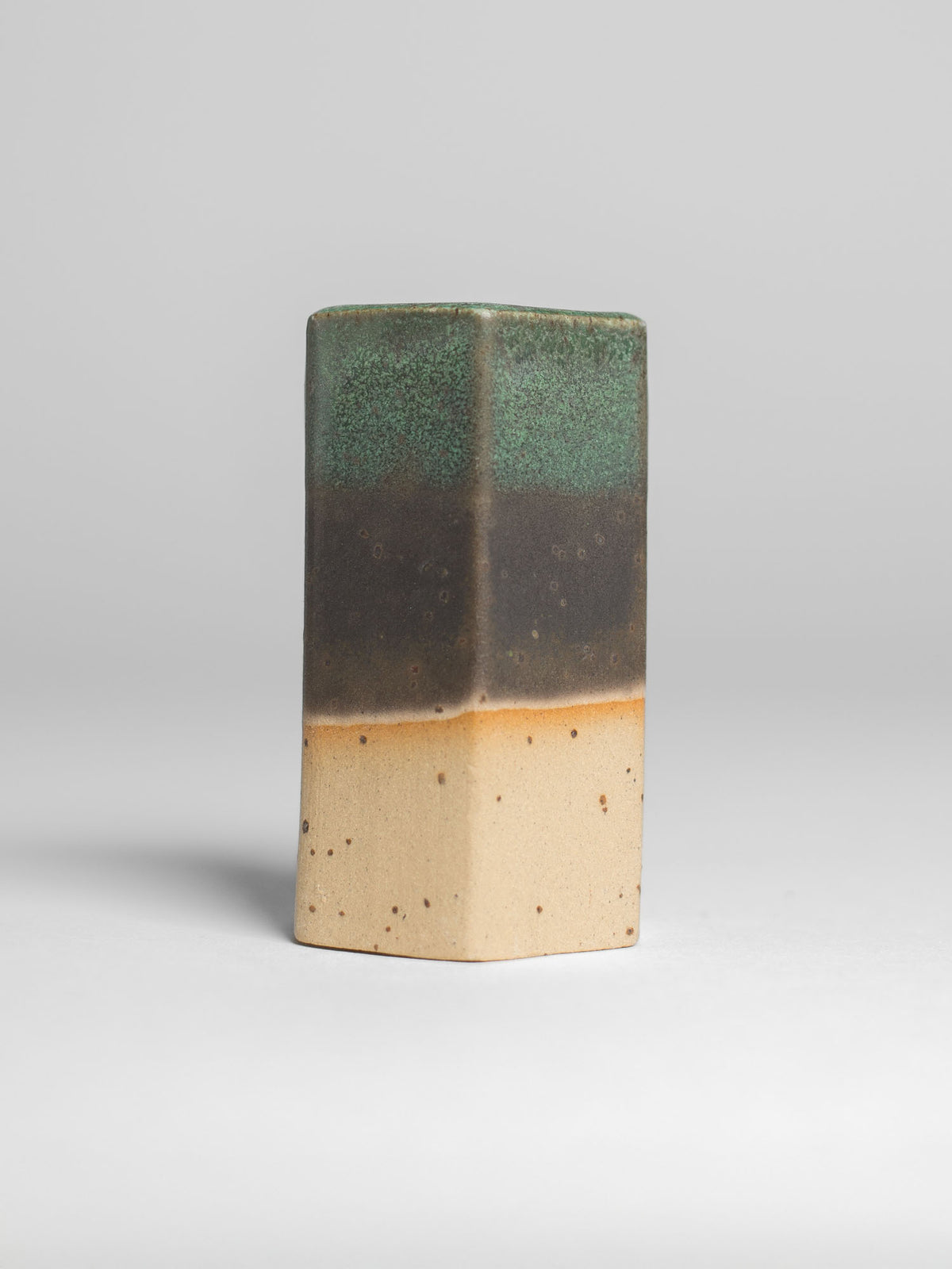 Malachite Green test tile on speckled clay, green over a broad dark brown band