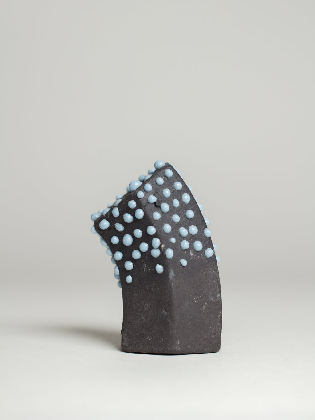 Light Blue Liquid Gloop on a dark test tile, pale blue droplets over black