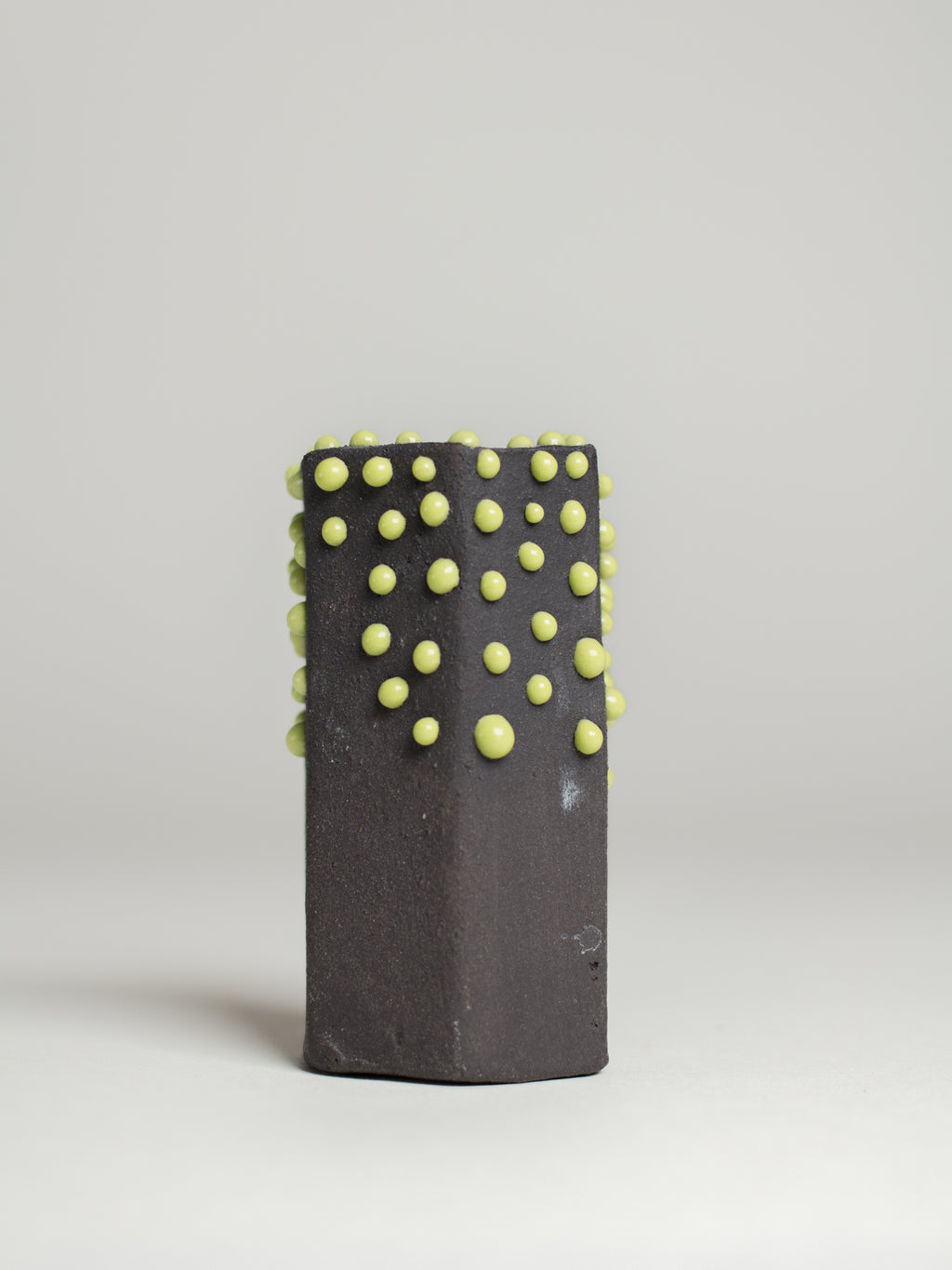 Green Liquid Gloop on a dark test cylinder, green droplets over black