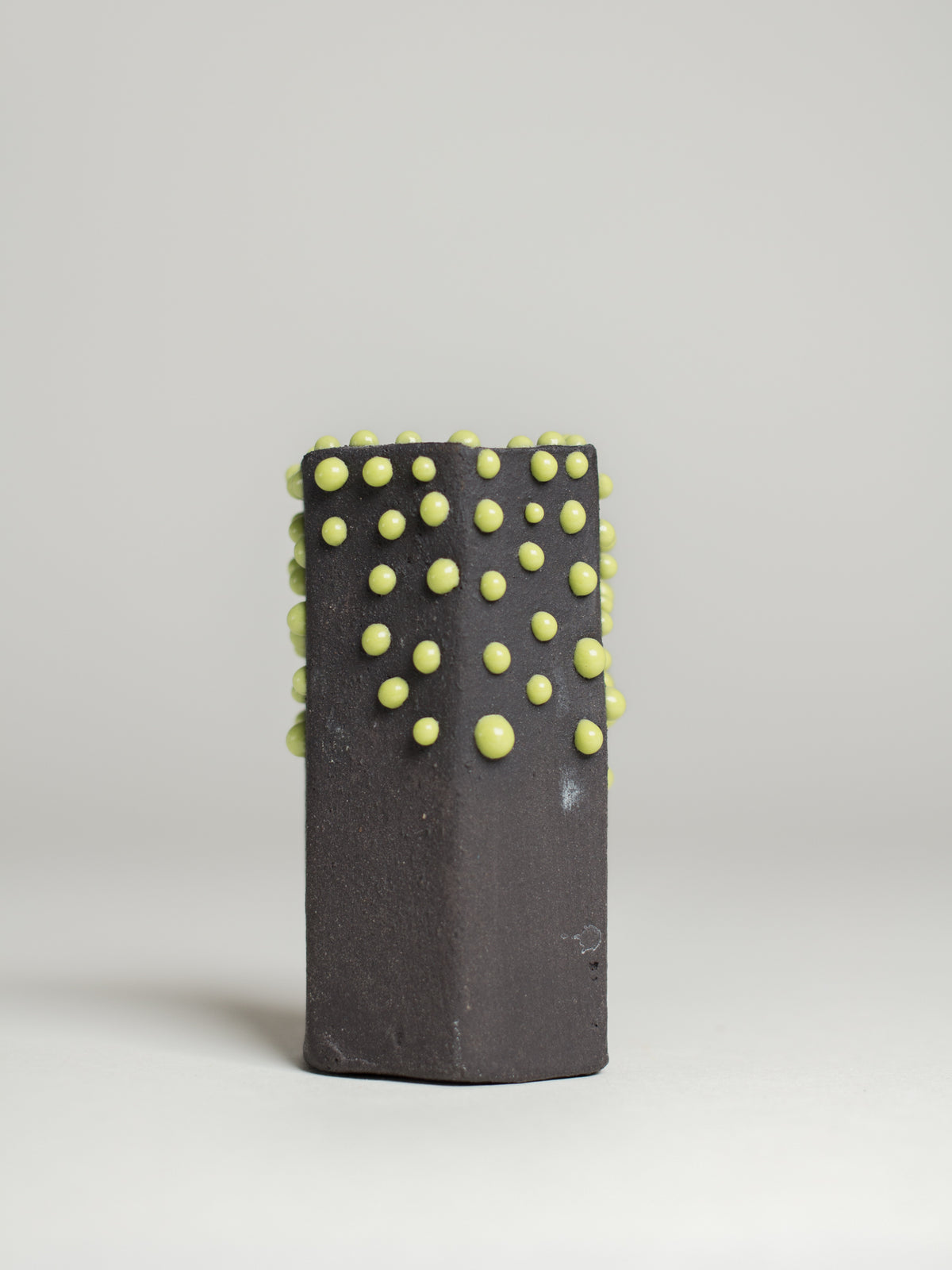 Green Liquid Gloop on a dark test cylinder, green droplets over black