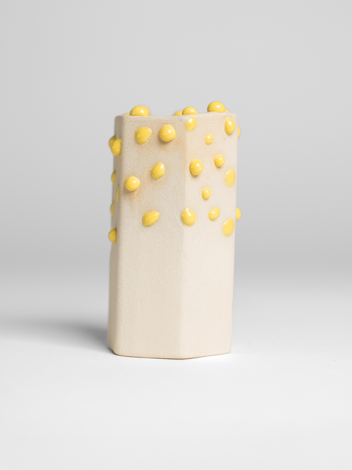 Yellow Liquid Gloop on a test cylinder, yellow droplets over cream