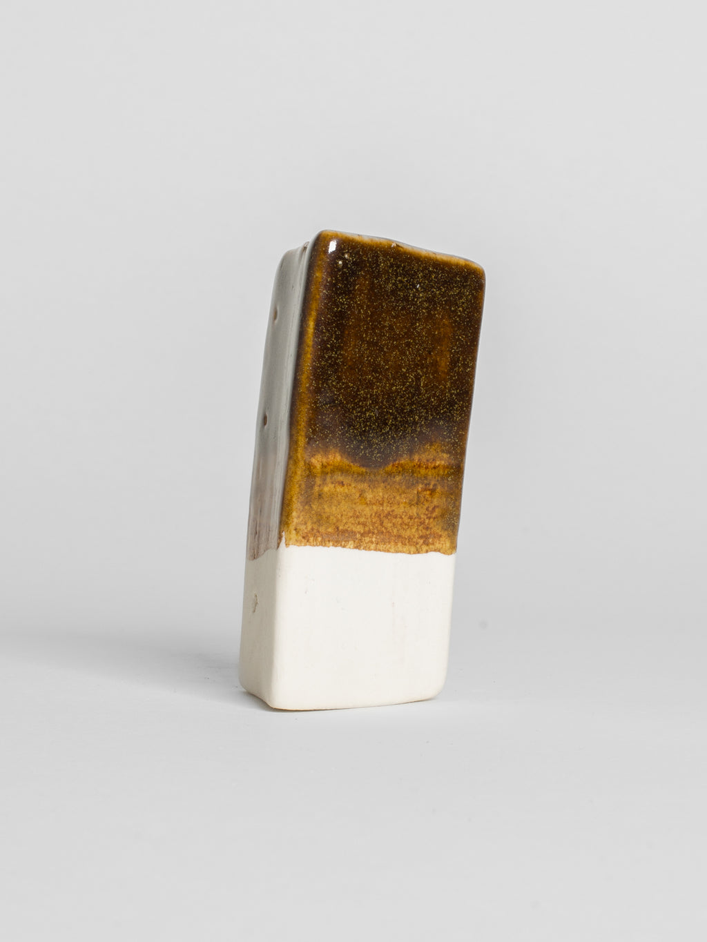 Golden Honey test tile on white clay, warm treacle brown breaking to clear gold at the edge
