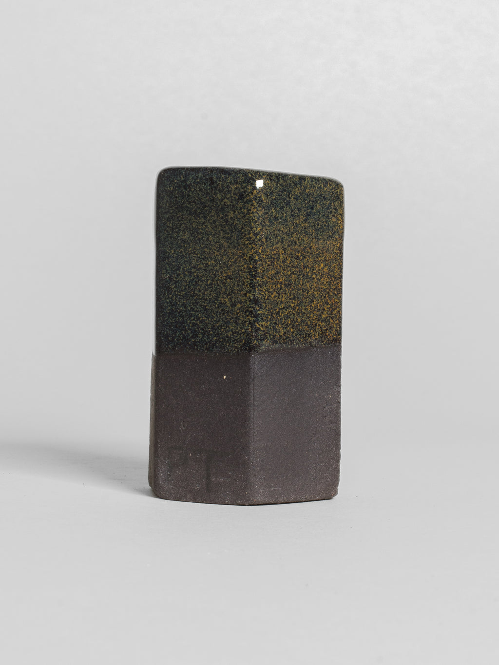 Tea Dust test tile on dark clay, dry olive-black speckle with gold flecks