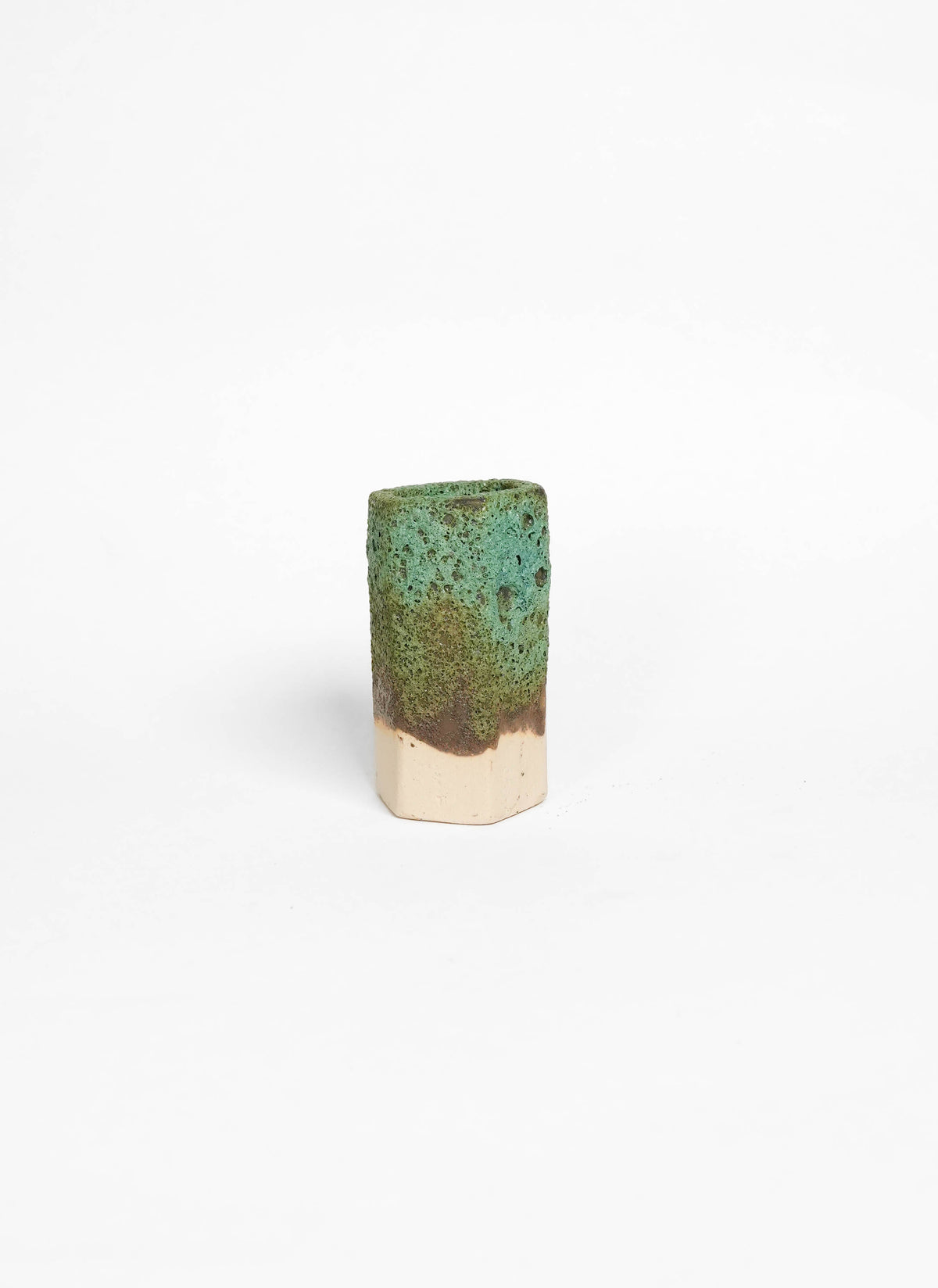 Cylindrical ceramic object with green textural glaze on white stoneware
