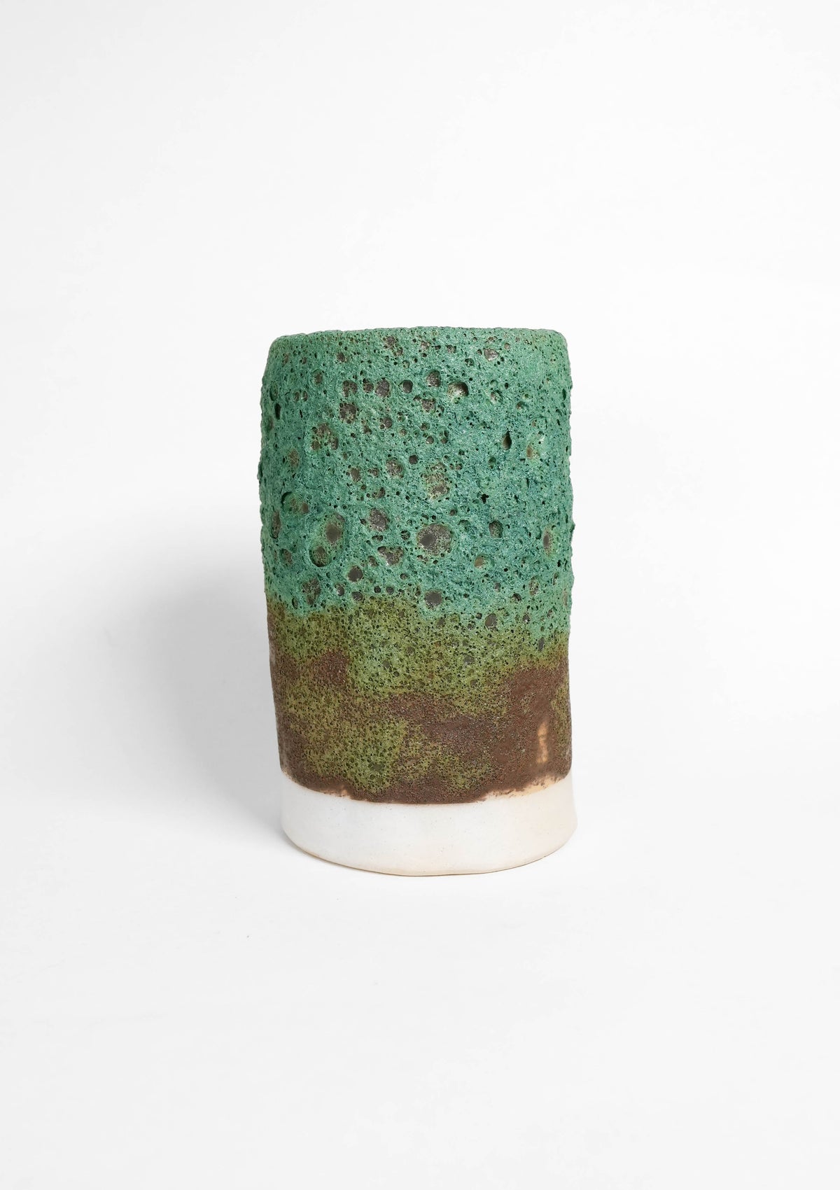 Cylindrical ceramic vase with gradient green to brown lava glaze on a white background