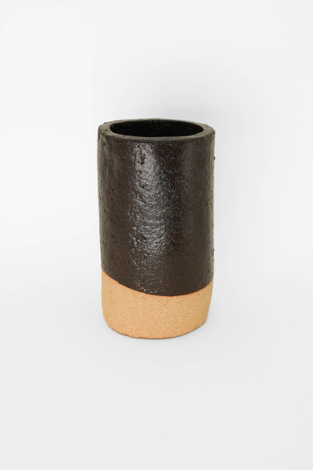 Silt Reclaimed Dark Brown glaze on a fired cylinder over pale clay