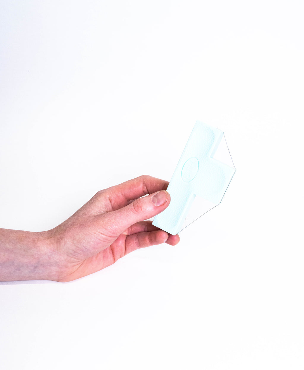 Hand holding the bevel wire tool face on, showing the cross-shaped body