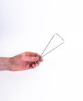 Hand holding the bicycle trimming tool, triangular wire frame opening away from the fingers