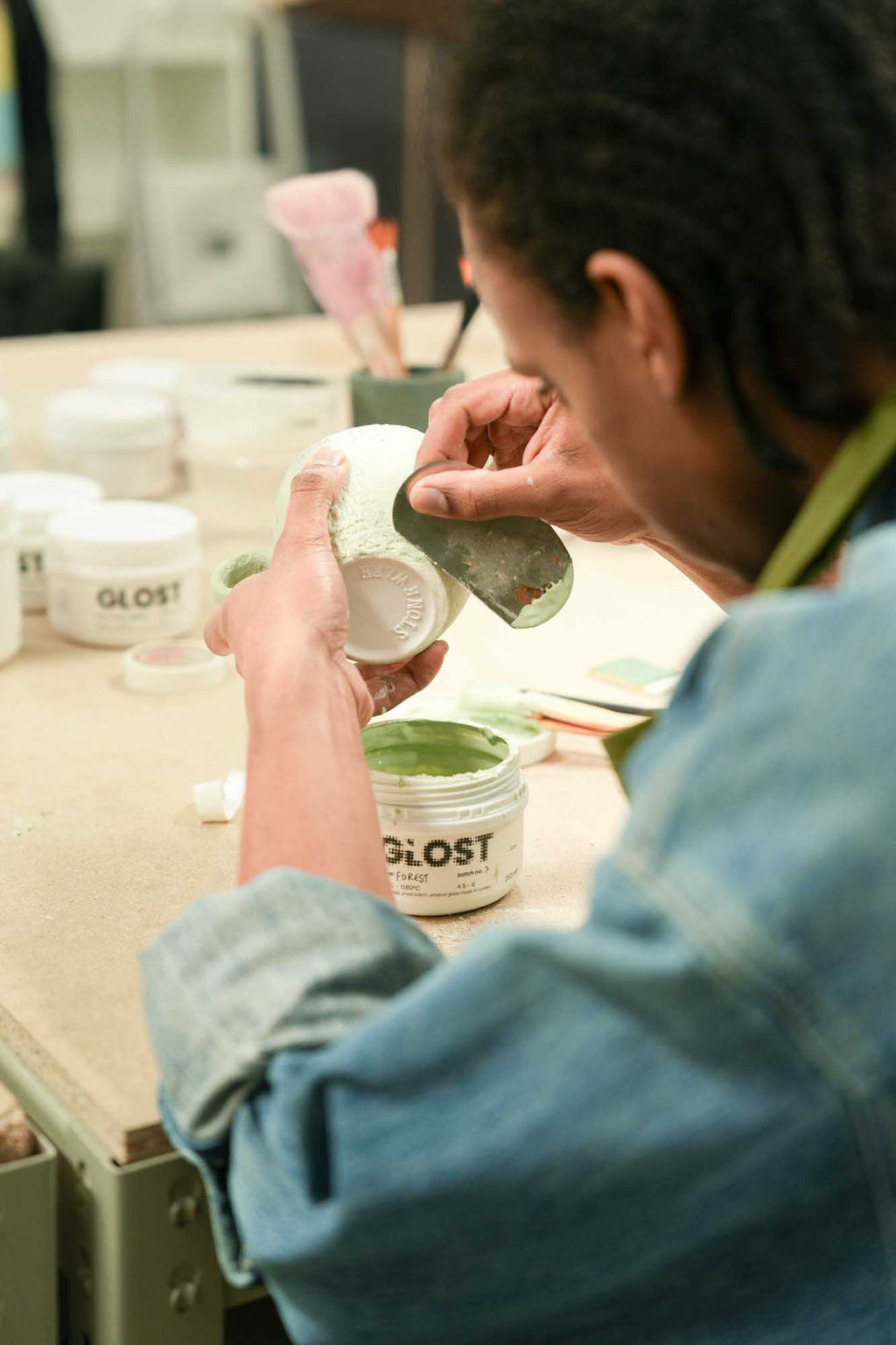 Person working with GLOST products on a wooden surface during a brush on workshop 