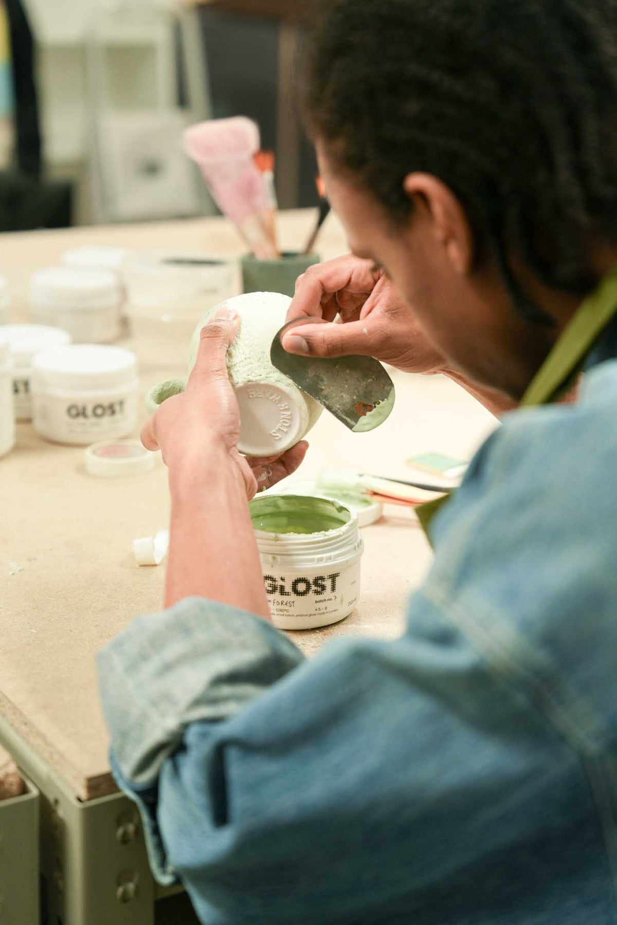Person working with GLOST products on a wooden surface during a brush on workshop 