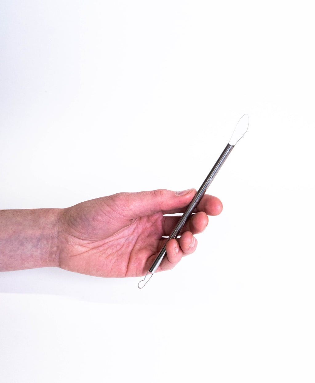 Hand holding a double-ended loop tool, broad rounded spade loop at the top and a small teardrop below