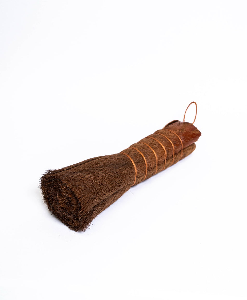 Long conical palm fibre brush bound with copper wire, lying on its side