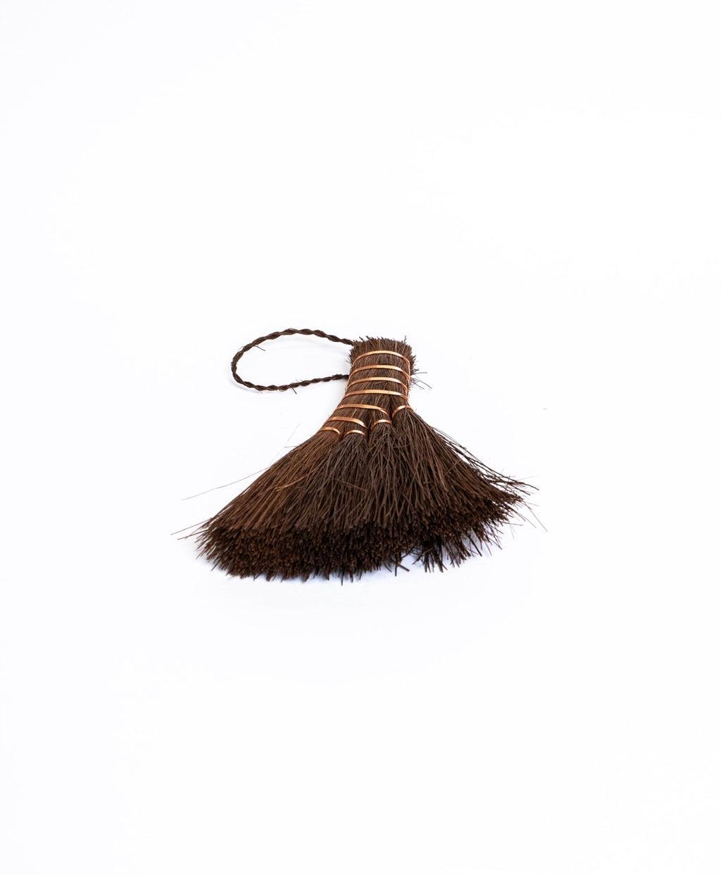 Wide fan palm fibre brush with copper binding and a plaited loop, seen from above