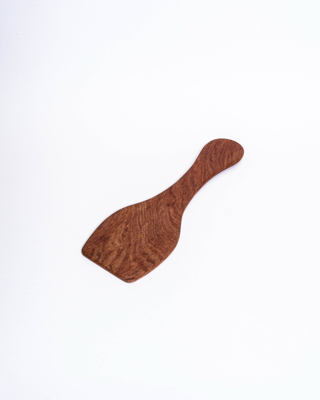 Figured hardwood paddle with a flared blade and a waisted handle, laid flat