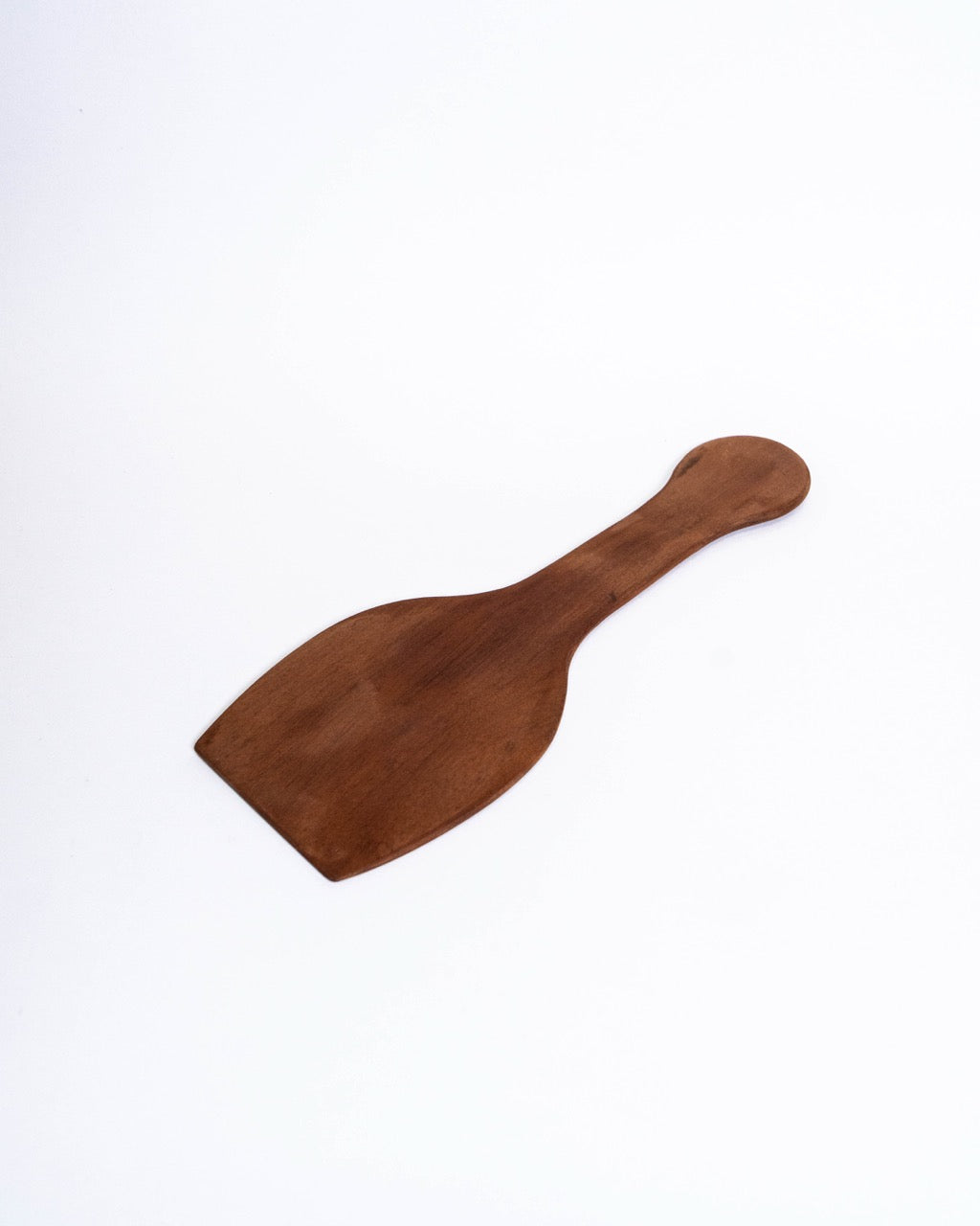 Plain hardwood paddle with a flared blade and a rounded handle end, laid flat
