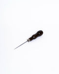 Pin tool with a dark curved wooden handle and metal ferrule, seen at an angle from above