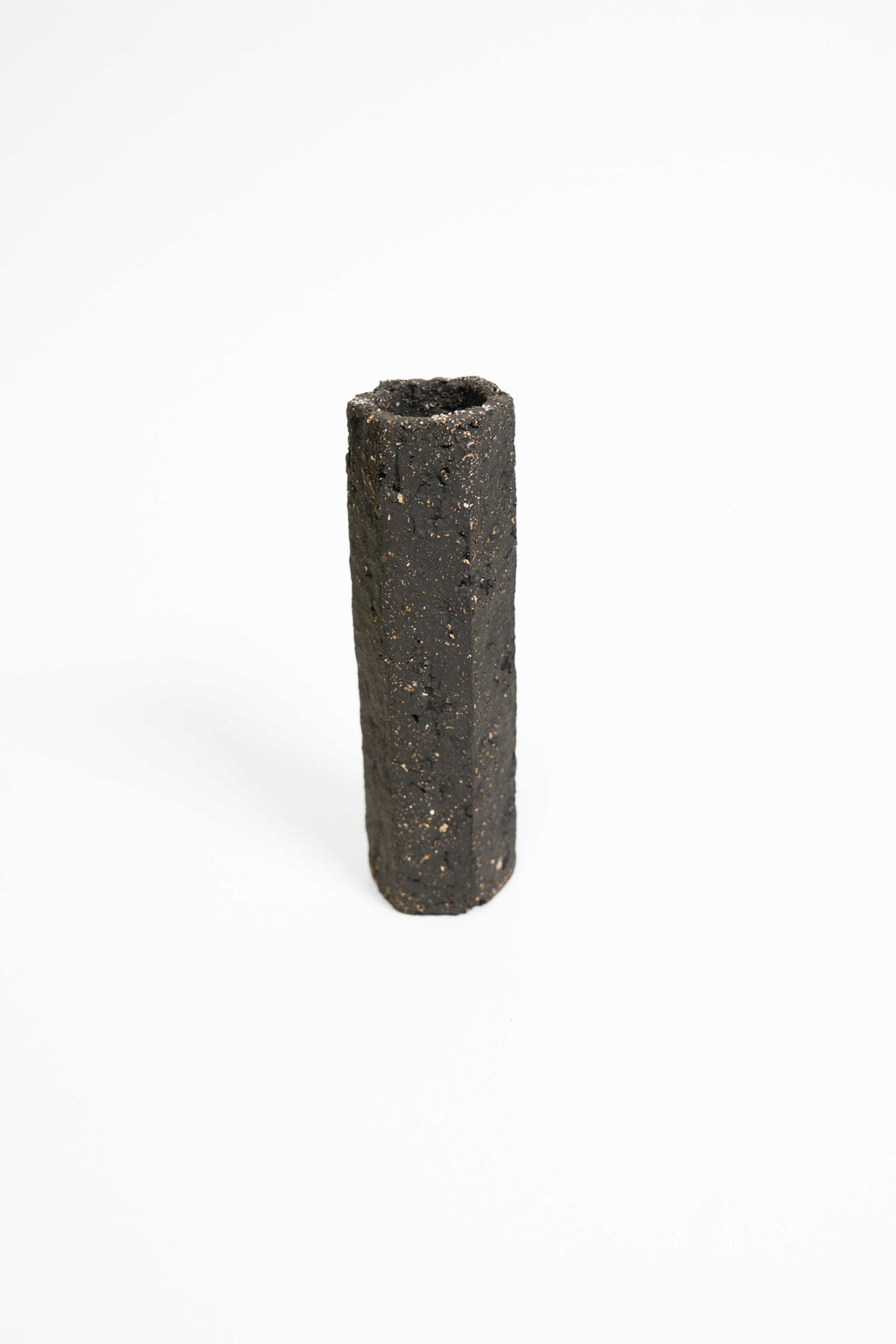 A tall faceted vessel in PF660 fired higher, black with gold grog flecking through the surface