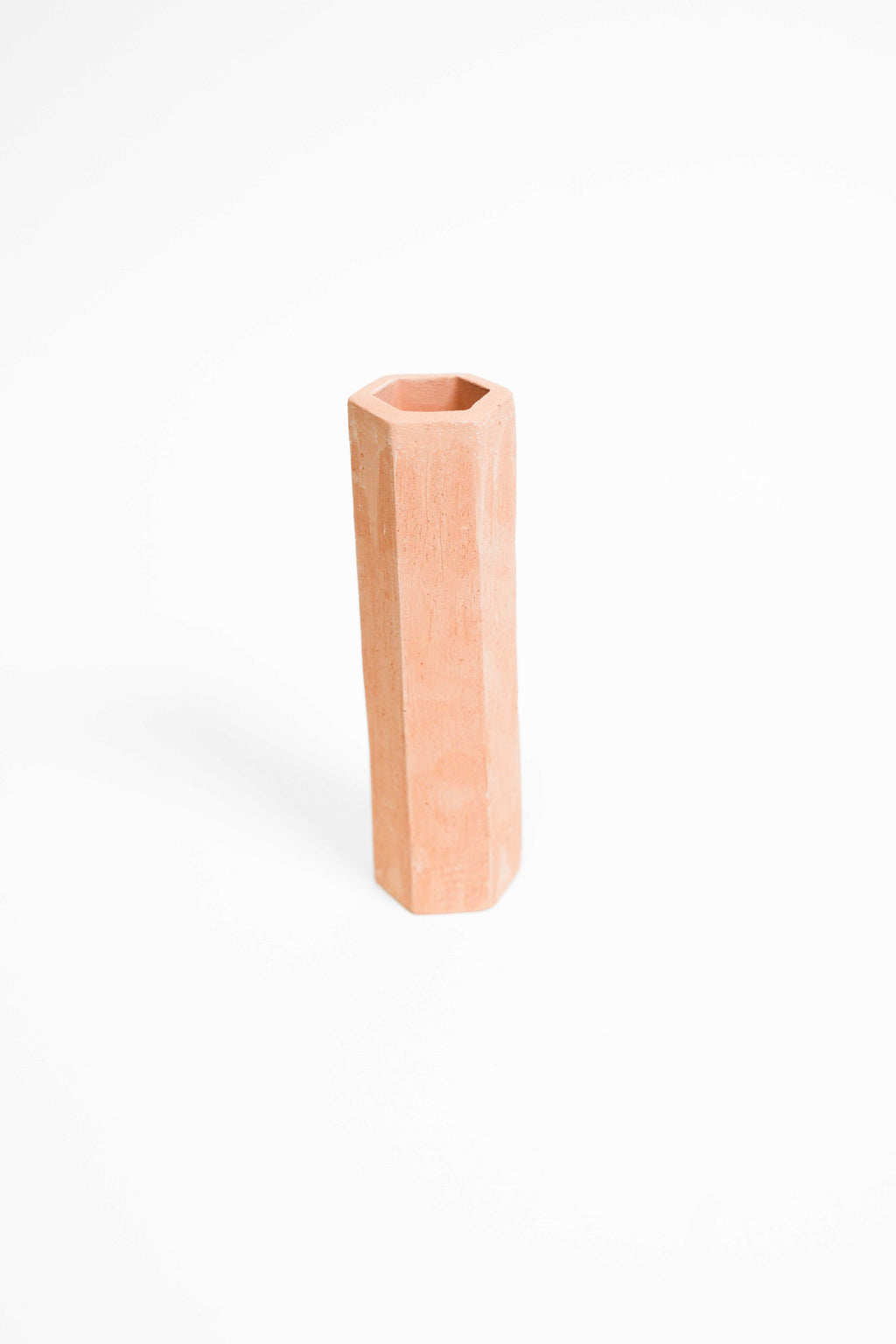 A tall faceted vessel in Rich Toasted fired low, unglazed terracotta pink