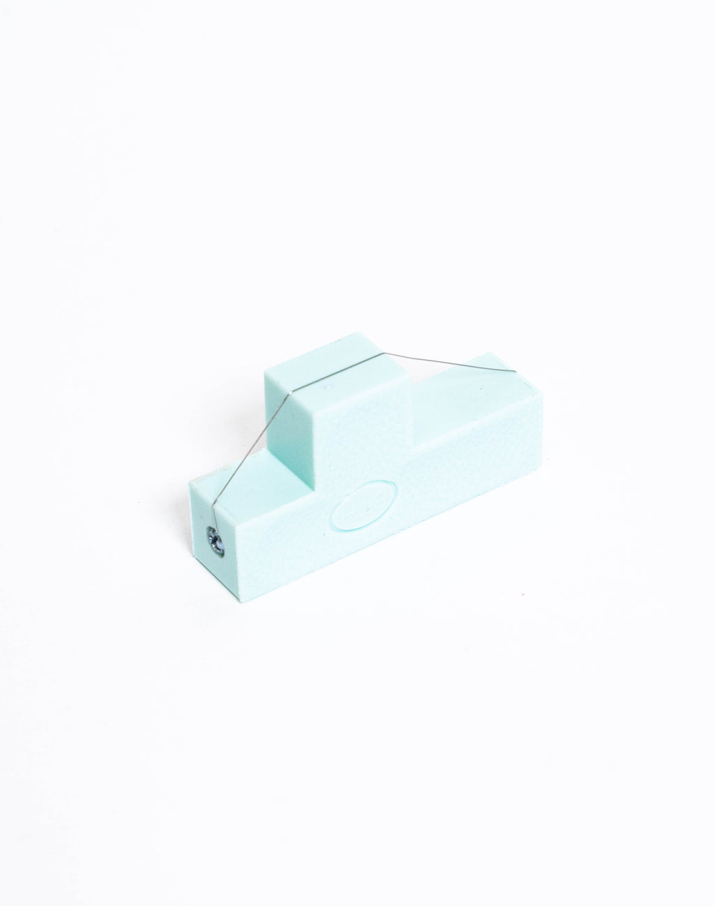 Pale blue bevel wire tool seen from the side, cutting wire strung across the stepped body
