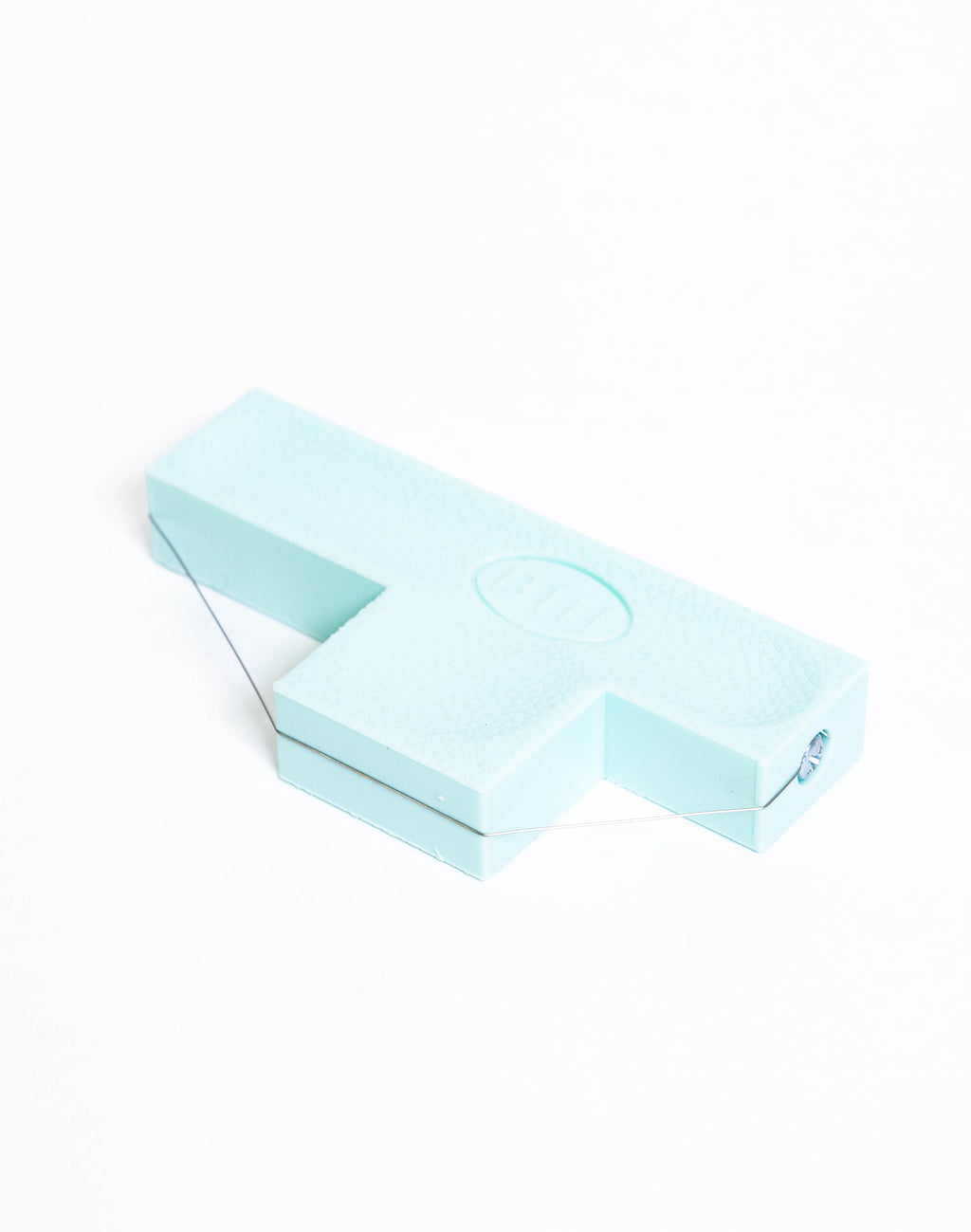 Pale blue bevel wire tool seen from above, showing the stamped oval on the flat face