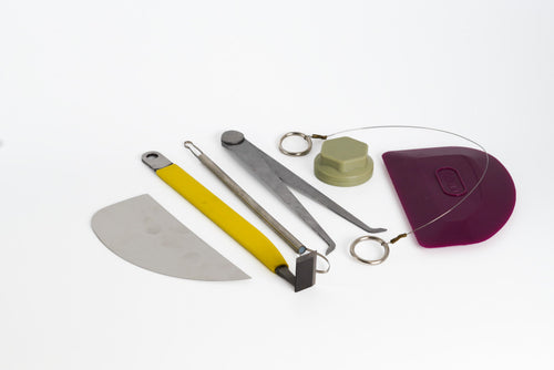 The GLOST Advanced Throwing Set laid out: metal-handled wire, tungsten trimming tool, trimming spinner, callipers, rubber rib, steel kidney and a loop trimmer.