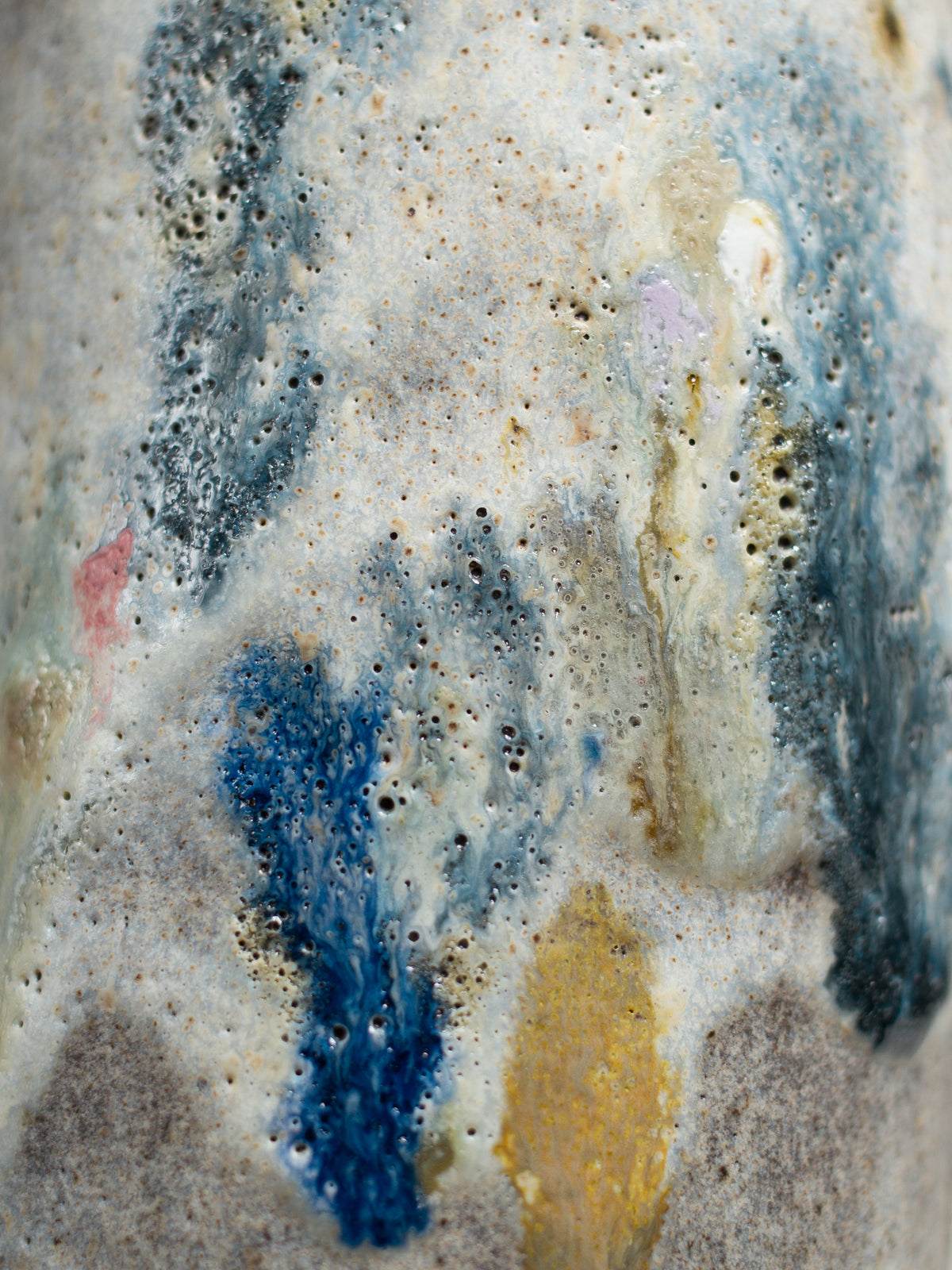 Two glazes layered on a fired test piece, one breaking over the other